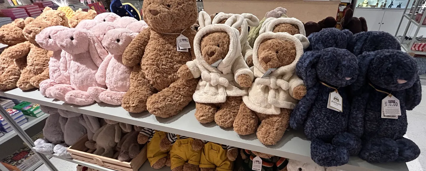 Shelf of genuine Jellycat soft toys with swing tags in a UK shop, photographed by Plushie Finds